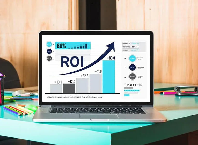 Laptop displaying ROI growth analytics with data charts, on a colorful office desk.