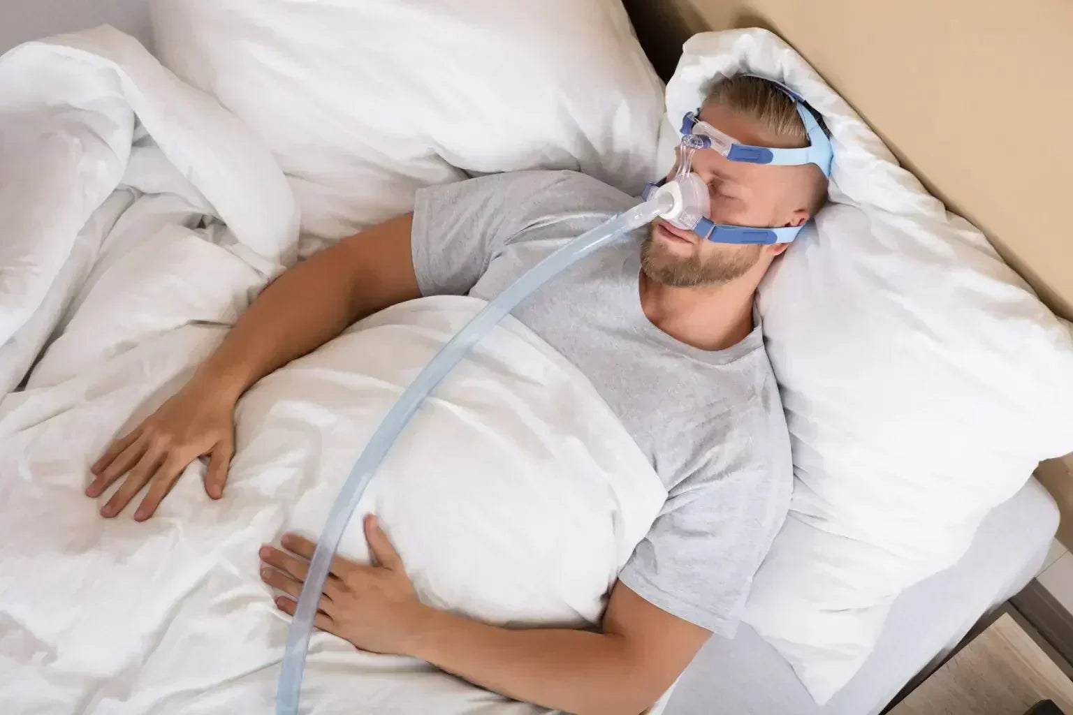 Man sleeping with a CPAP mask in bed, respiratory therapy device for sleep apnea