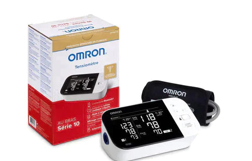 Digital blood pressure monitor with cuff and packaging on white background