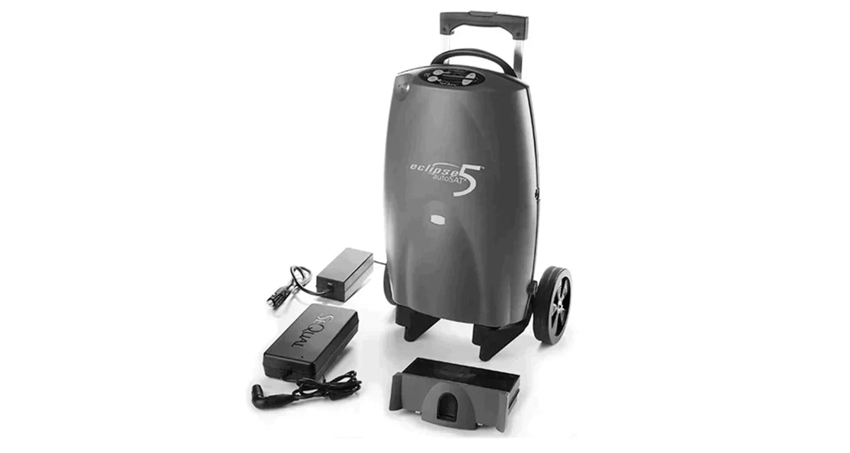Portable oxygen concentrator with wheels, battery pack, and power adapter on white background