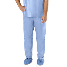 Man wearing light blue disposable medical scrubs and shoe covers, standing on white background.