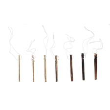 Set of seven assorted wooden tongue depressors with attached white strings on white background