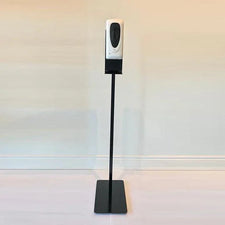 Automatic hand sanitizer dispenser on a black metal stand in a clean indoor setting