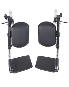 Pair of black wheelchair leg rests with padded calf supports and footplates on white background