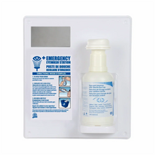 Wall-mounted emergency eyewash station with instructions and sterile eyewash solution bottle
