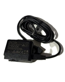 Black medical device power adapter with coiled cable on white background