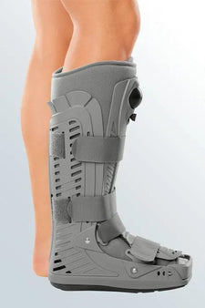 Person wearing a grey orthopedic walking boot for foot or ankle injury recovery