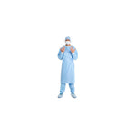 Healthcare worker wearing full blue surgical gown, mask, cap, and shoe covers on white background