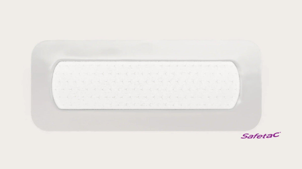 Rectangular adhesive medical wound dressing with white absorbent pad, Safetac logo