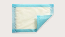 Disposable blue and white underpad for medical or incontinence care on white background