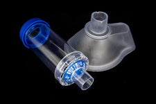 Clear and blue asthma inhaler spacer with mask for respiratory therapy on black background