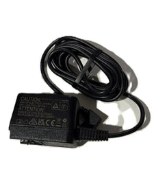 Black medical device power adapter with coiled cable on white background