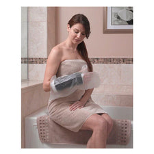 Woman in towel using waterproof arm cast protector while sitting on bathtub