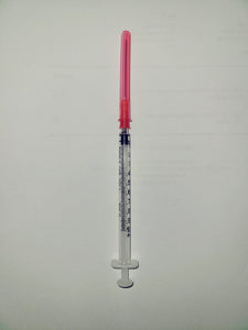 Medical syringe with measurement markings and pink safety cap on white background