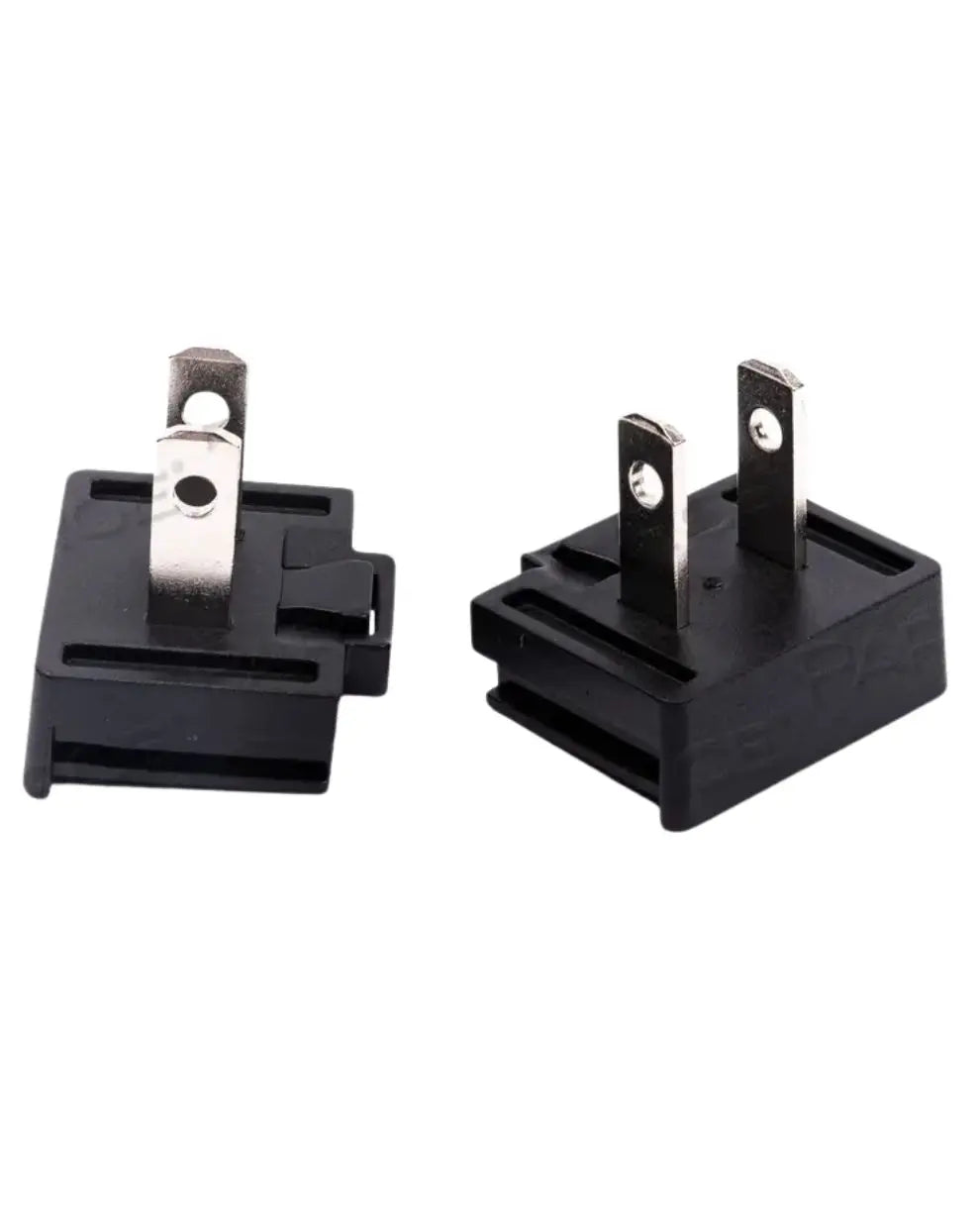 Close-up of two black electrical plug adapters with metal prongs for home medical equipment