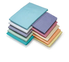 Stack of multi-colored disposable medical dental bibs for clinic and home care use